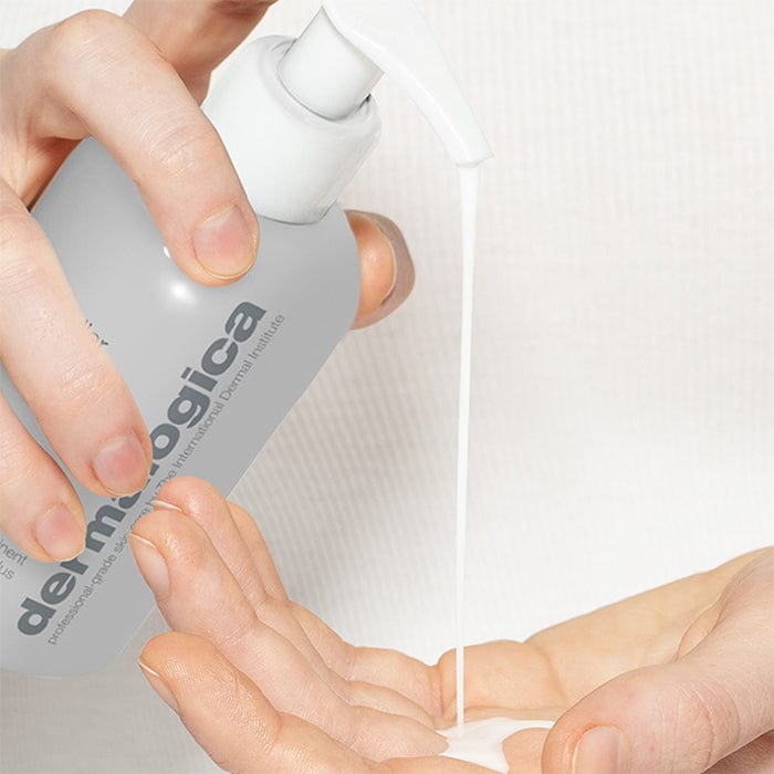 Hände drücken eine Flüssigkeit aus einem -Flaschenspender in eine Handfläche.