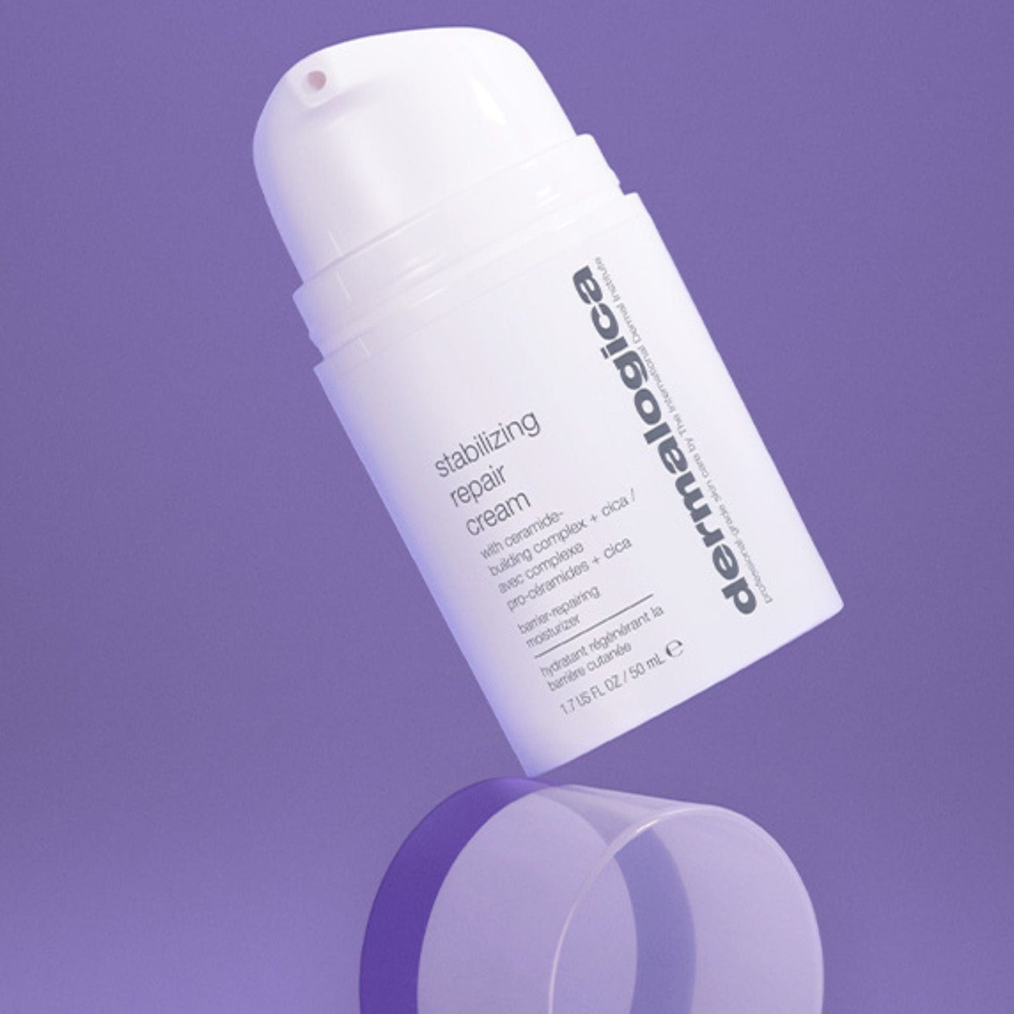 Eine weiße Flasche Stabilizing Repair Cream + UltraCalming Cleanser ist vor einem violetten Hintergrund abgebildet, unter dem sich ein durchsichtiges zylindrisches Objekt befindet.
