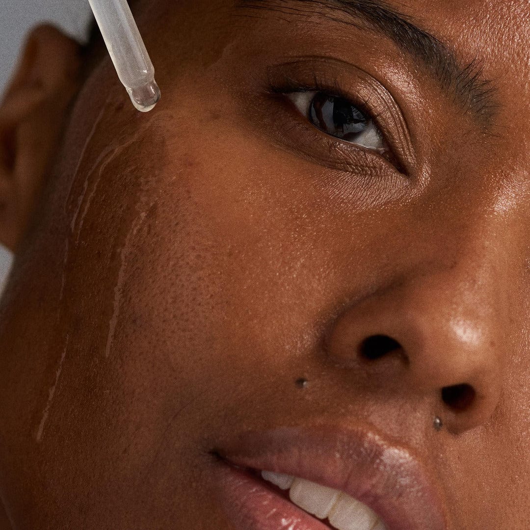 Nahaufnahme einer Person, die das Circular Hydration Serum mit einer Pipette auf ihre Wange aufträgt; ihre Haut und Gesichtszüge sind deutlich zu erkennen.