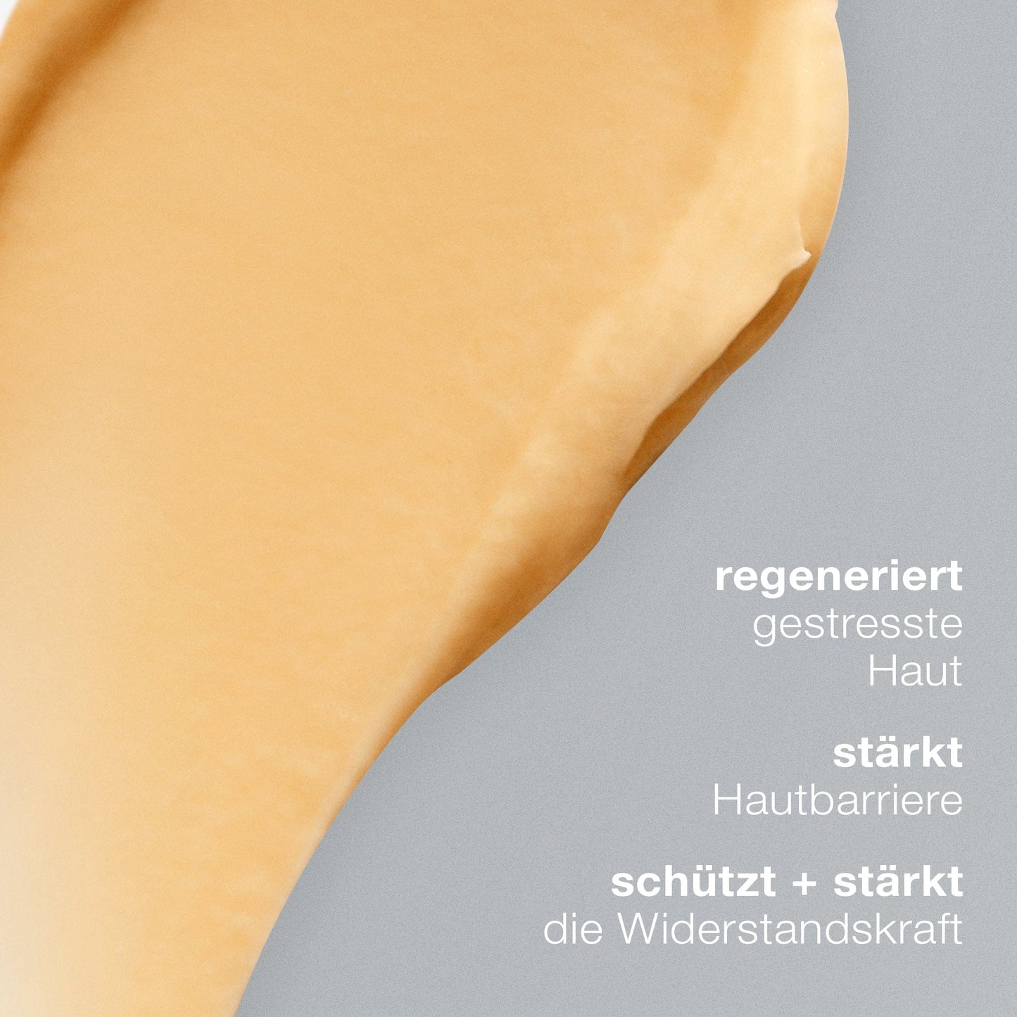 Eine Nahaufnahme eines hautfarbenen Cremeschmierens auf Grau mit deutschem Text, der die Vorteile der antioxidativen MultiVitamin Power Recovery Masque beschreibt: Regeneration, Stärkung der Barriere und Schutz.