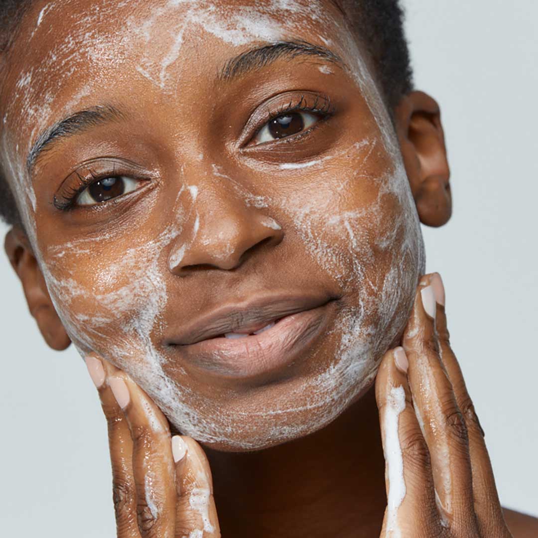 Eine Person trägt das Special Cleansing Gel mit beiden Händen sanft auf das Gesicht auf und blickt dabei in die Kamera - so bleibt der natürliche Feuchtigkeitshaushalt der Haut erhalten.