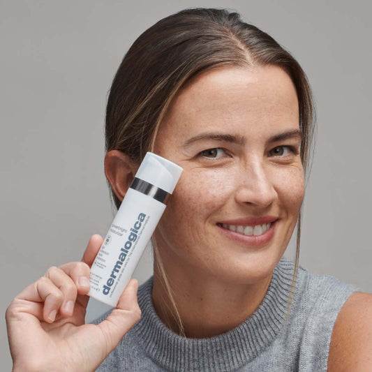 Lächelnde Person hält ein Produkt der Marke in der Hand.