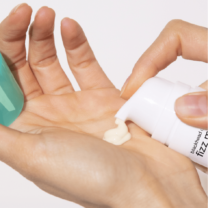 Eine Hand drückt eine Creme aus einer Tube
